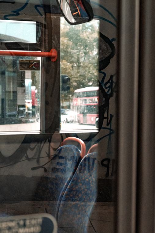 Out of a bus window, the street doubled in the glass