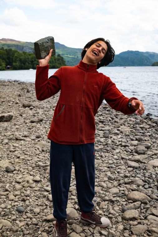 Holding a stone up on the shore