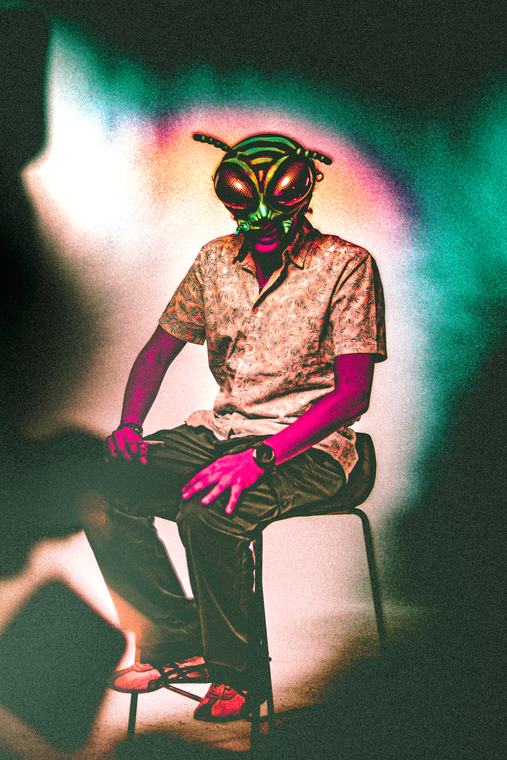 Seated, green halo, shot against a white wall